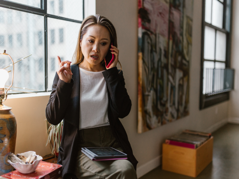 woman on phone and looking annoyed in an apartment